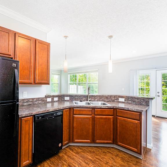 a black fridge in a kitchen with wooden cabinets.