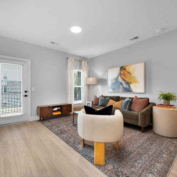 a living room with a brown sofa and a painting on the wall.