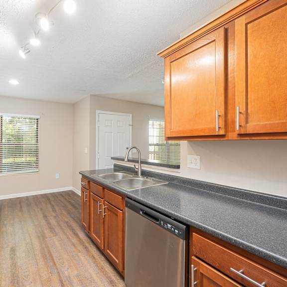 an empty kitchen with wood cabinets and a counter top and a sink