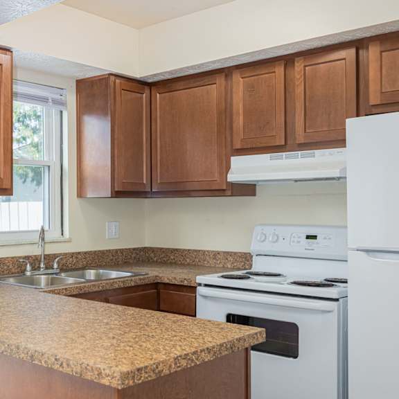 a kitchen with brown cabinets and a white stove.