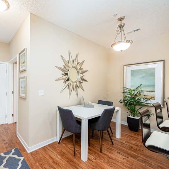 a dining room with a table and chairs and a mirror