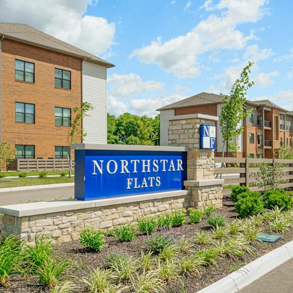 a sign flats in front of an apartment building