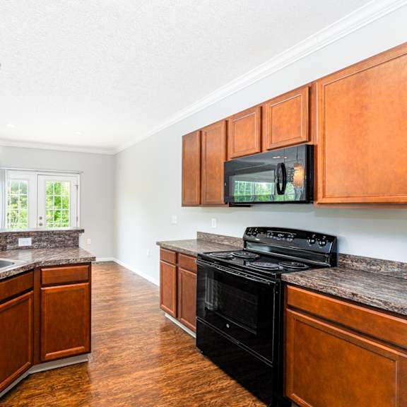 a kitchen with wooden cabinets and a black stove top oven.