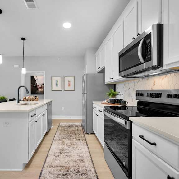 a modern kitchen with a large island and stainless steel appliances.