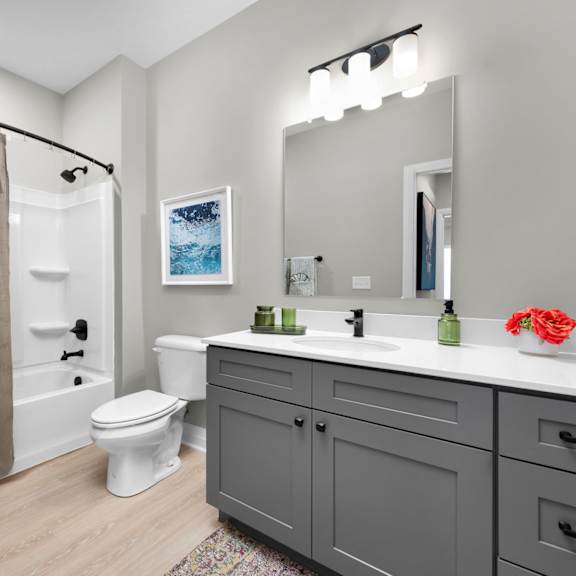 a bathroom with a toilet, sink, and shower.