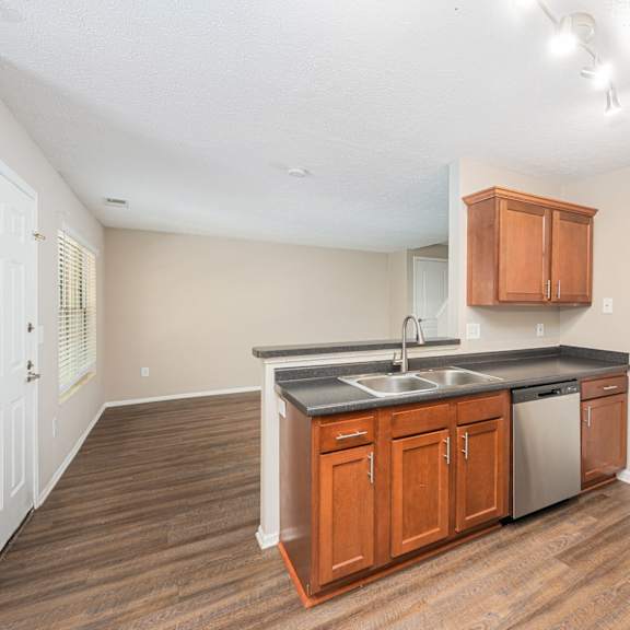 a kitchen with wooden cabinets and a stainless steel sink and a refrigerator