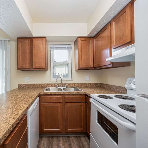 a kitchen with brown cabinets and a white stove top oven.