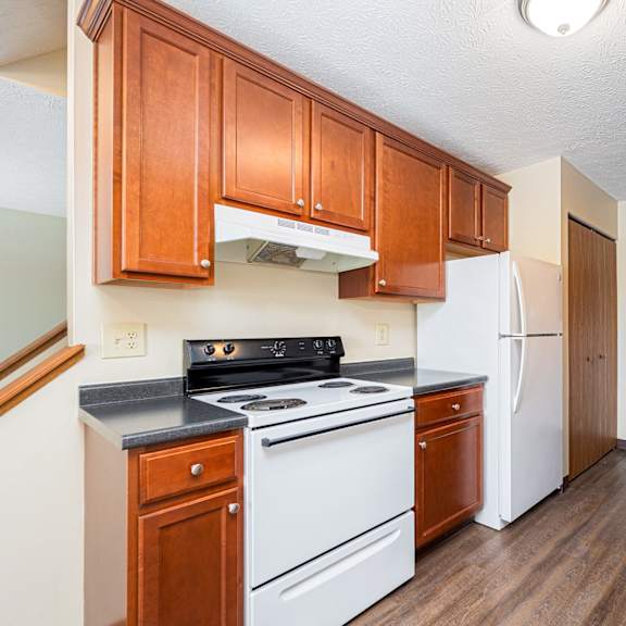 a kitchen with white appliances and wooden cabinets