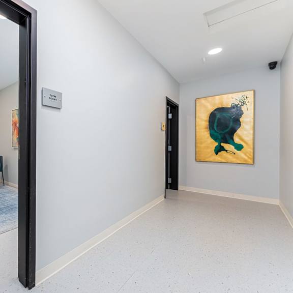 a room with a painting of a green animal on the wall.