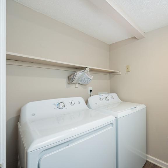 a white washer and dryer in a laundry room with a white door