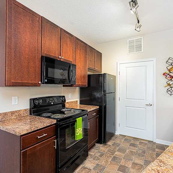 a kitchen with black appliances and granite counter tops