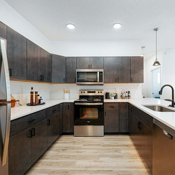 a large kitchen with wooden cabinets and stainless steel appliances