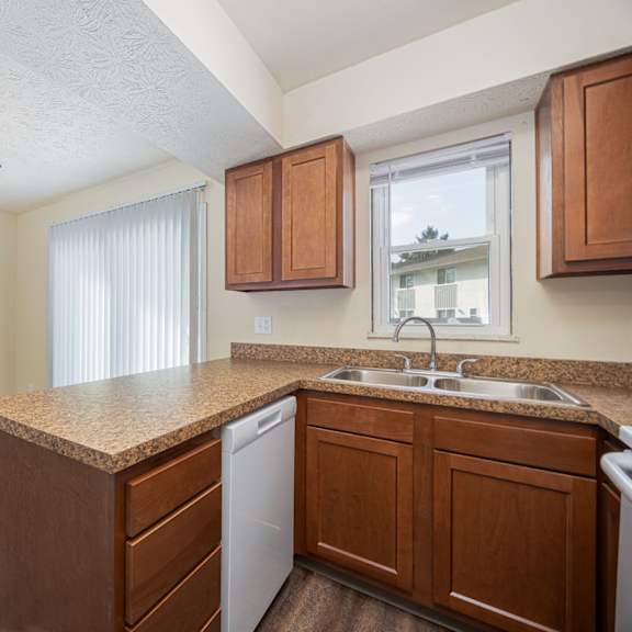 a kitchen with a white ceiling fan and wooden cabinets.