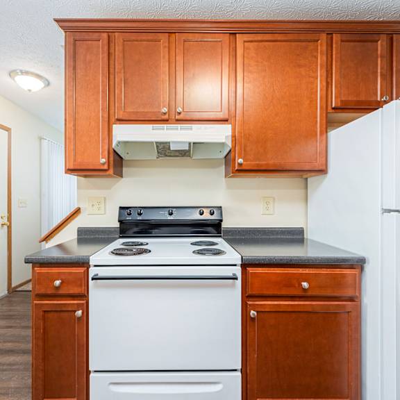 a kitchen with white appliances and wooden cabinets