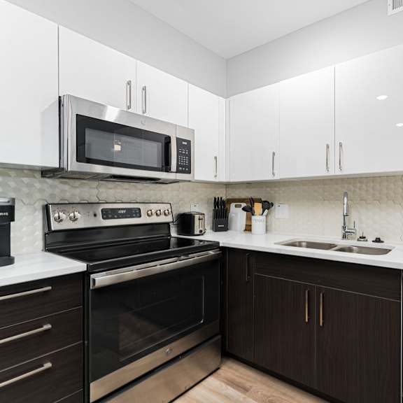 a modern kitchen with a black oven and a white microwave.