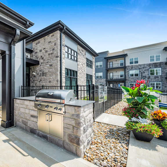 a modern house with a stone facade and a black gate.