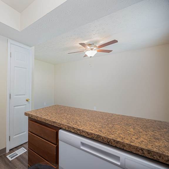 a kitchen with a counter and a fan on the ceiling.
