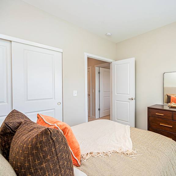 a bedroom with a bed and dresser with a mirror