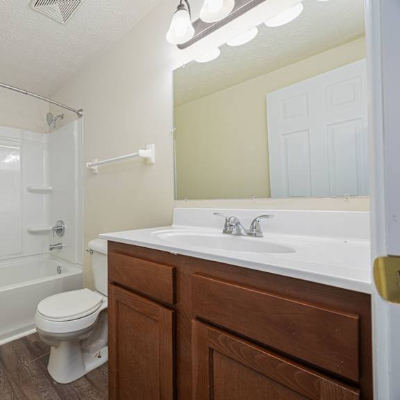 a white toilet sits next to a white sink in a bathroom.