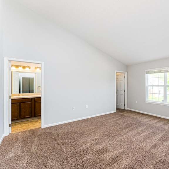 a room with a carpeted floor and a window.