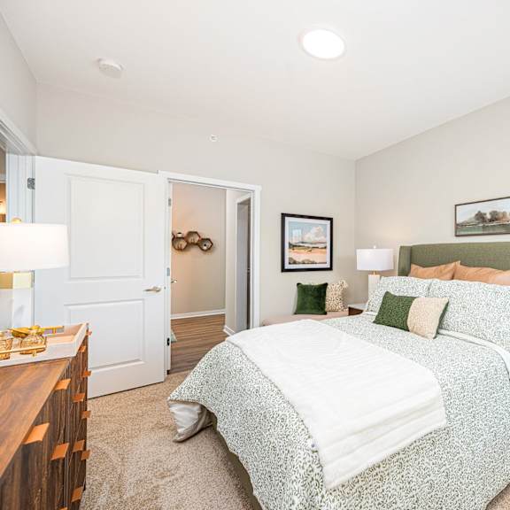 a bedroom with a bed and two lamps on top of it