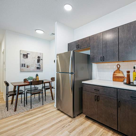 a kitchen with wooden cabinets and a stainless steel refrigerator