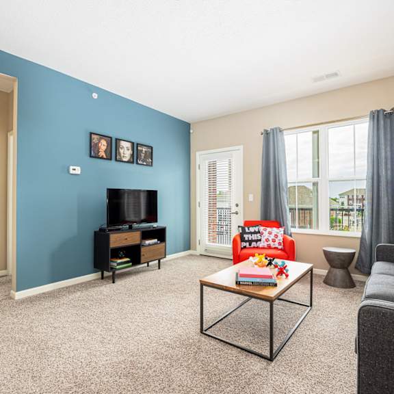 a living room with a blue wall and a couch and a table