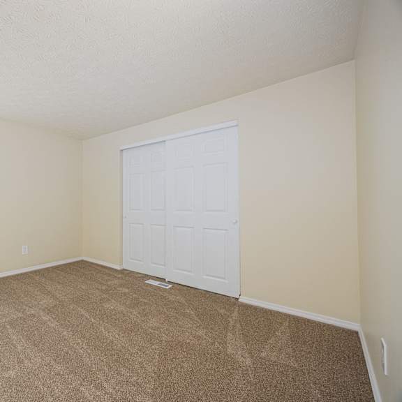 a room with a white door and carpeted floor.