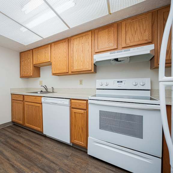 a kitchen with white appliances and wooden cabinets.