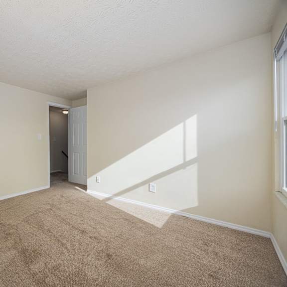a room with a carpeted floor and a door in the background.