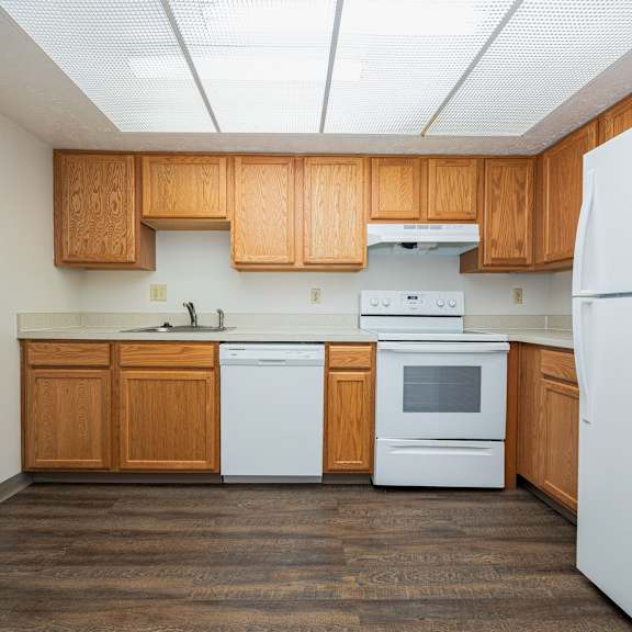 a kitchen with white appliances and wooden cabinets.