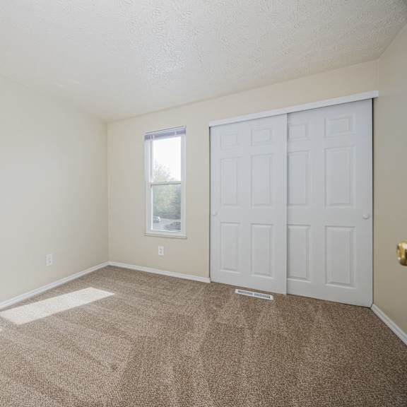 a room with a carpeted floor and a white door.
