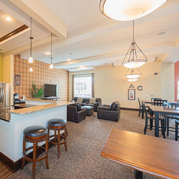 a kitchen with a bar and a living room with a table and chairs