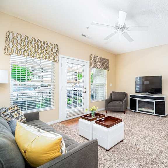 a living room with a couch and a ceiling fan