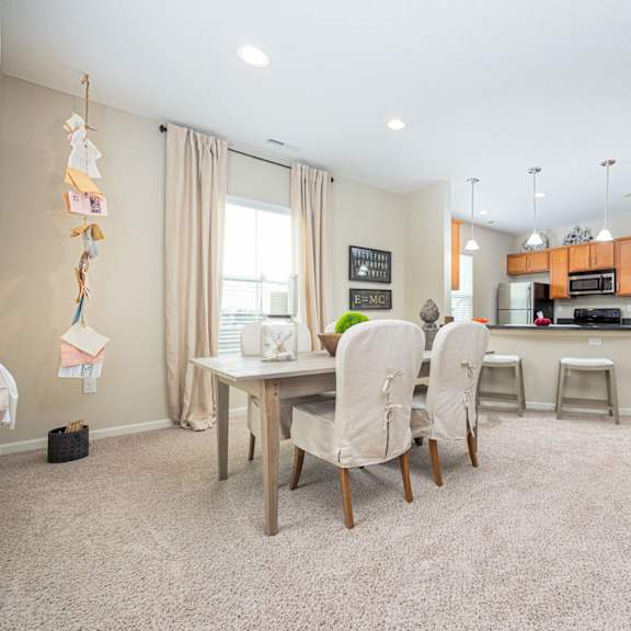 a kitchen with a dining table and chairs in the middle of the room.