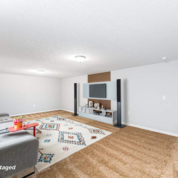 a living room with a grey couch and a rug with a pattern on it.