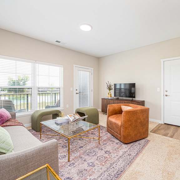 a living room with a couch and a chair and a television