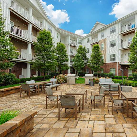 an outdoor patio with tables and chairs at an apartment complex