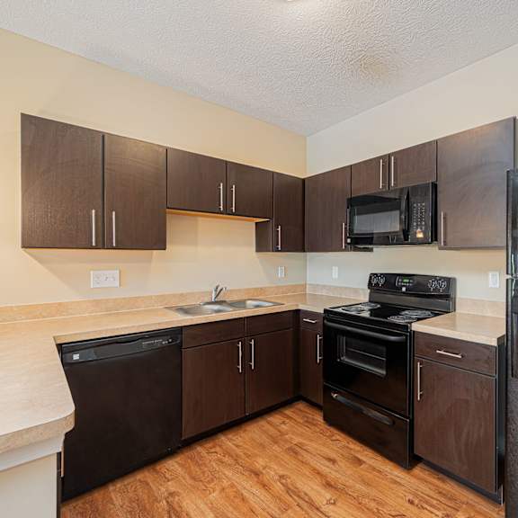 a kitchen with black appliances and wooden cabinets