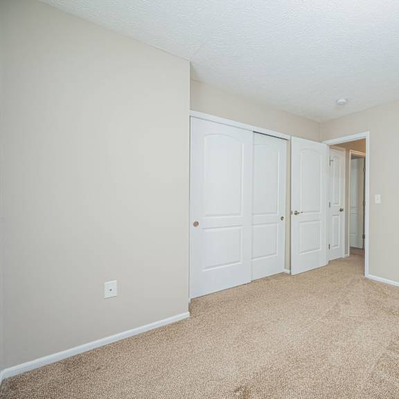 a bedroom with two closets and a door to a hallway