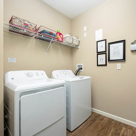 a washer and dryer in a laundry room with a door to a closet