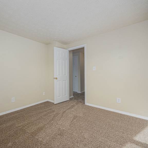 a room with a carpeted floor and a white door.