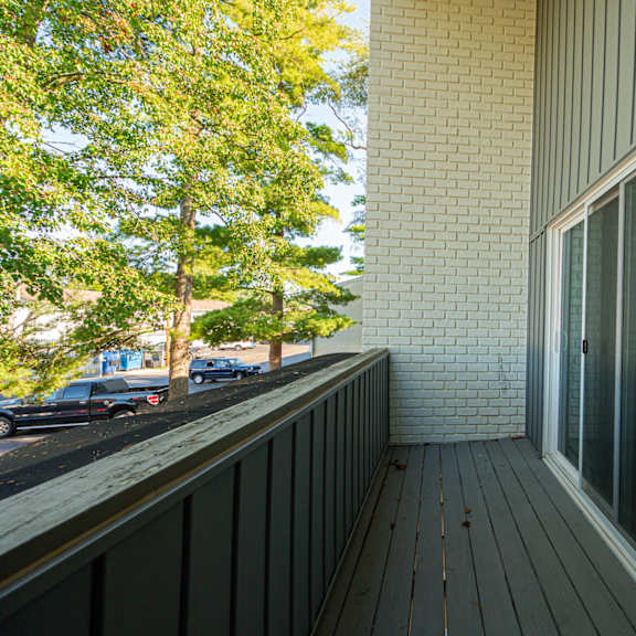 a balcony with a view of the street and trees