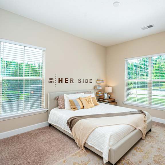 a bedroom with a bed and two windows