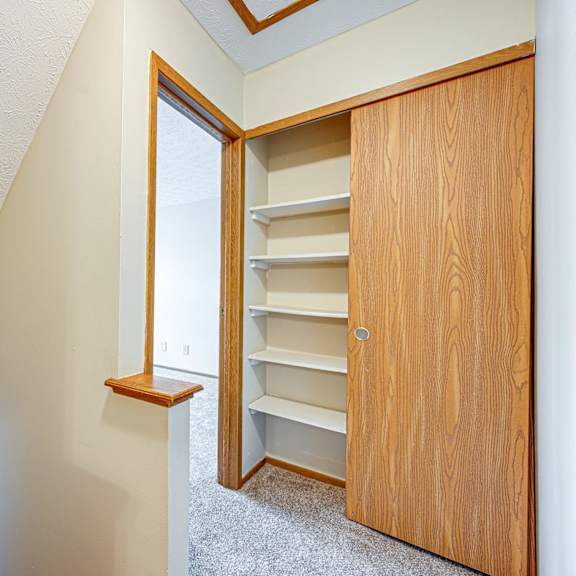 a closet in a upstairs room with a window and a door