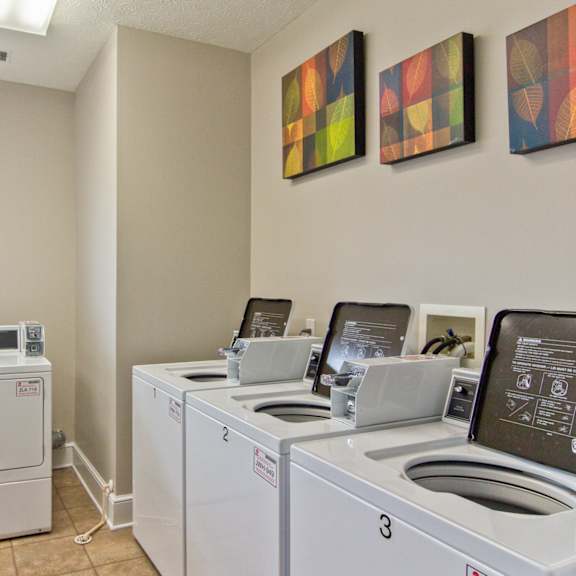 washers and dryers in the laundry room of an apartment building