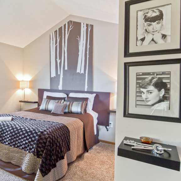 a bedroom with a bed and pictures on the wall