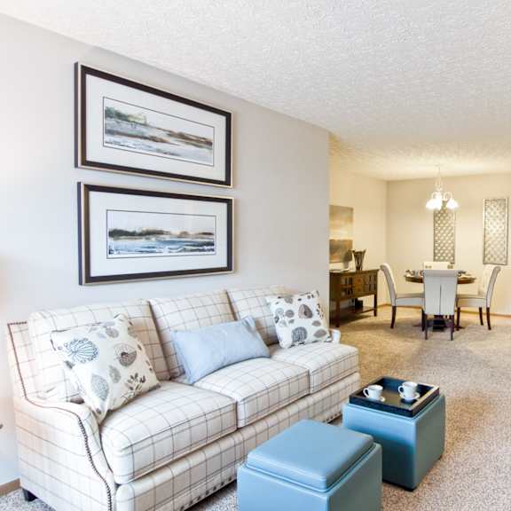 a living room with a couch and a table with a kitchen in the background