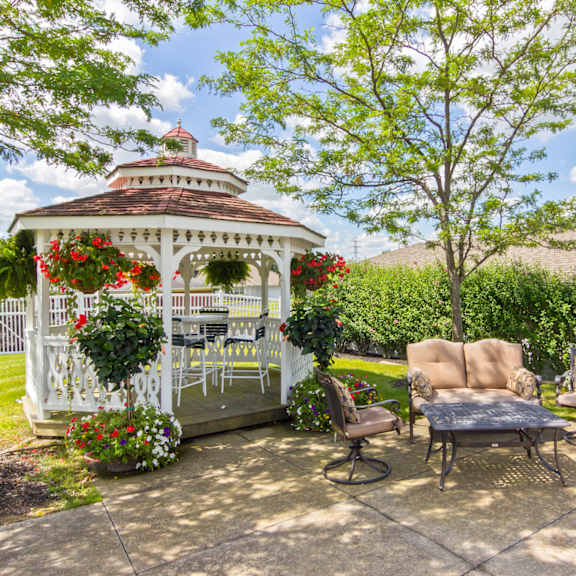 a gazebo on a patio with chairs and a table