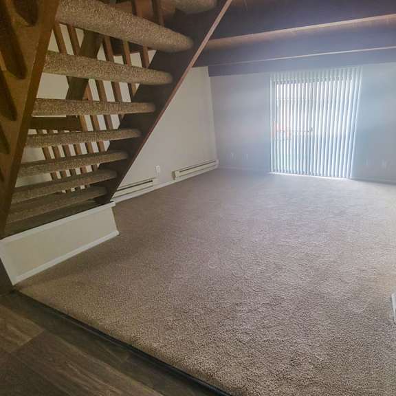 a view from the bottom of the stairs looking into the living room